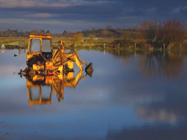 A tractor sits in flood water still present in fields on the Somerset Levels near Langport in Somerset