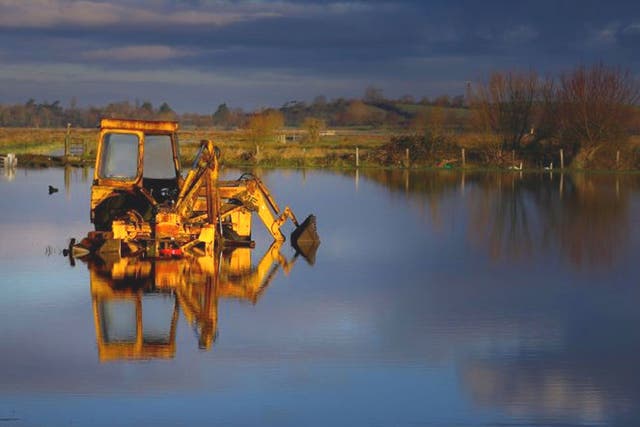 A tractor sits in flood water still present in fields on the Somerset Levels near Langport in Somerset