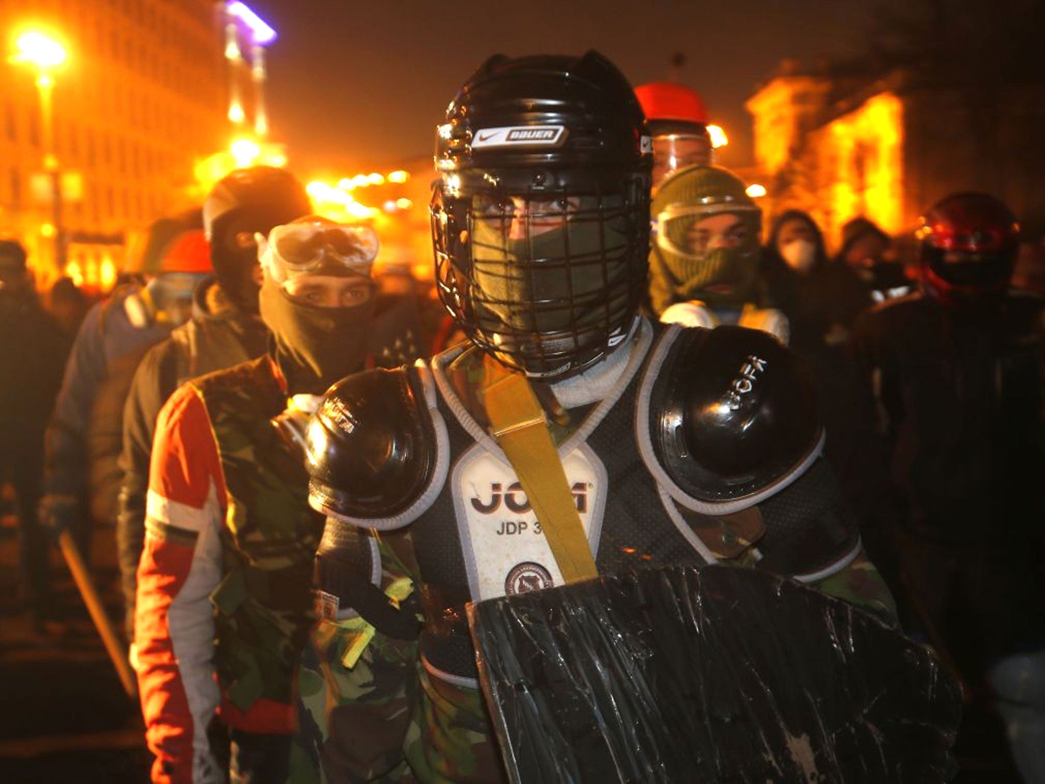 Protesters clad in improvised protective gear prepare for a clash with police in central Kiev