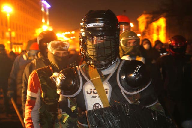 Protesters clad in improvised protective gear prepare for a clash with police in central Kiev