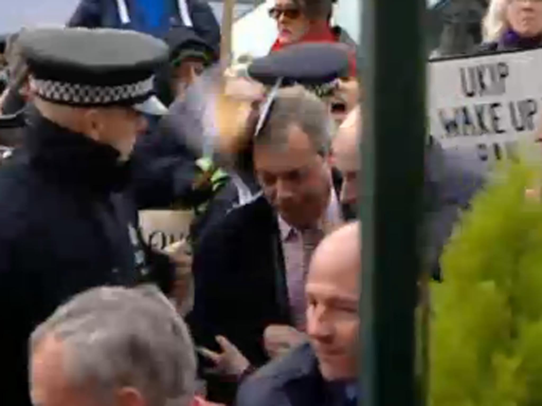 The moment Ukip leader Nigel Farage is hit over the head with a placard while in Kent yesterday