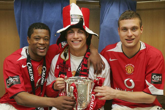 Patrice Evra, Cristiano Ronaldo and Nemanja Vidic of Manchester United pose with the Carling Cup trophy in the dressing room after their 2006 win