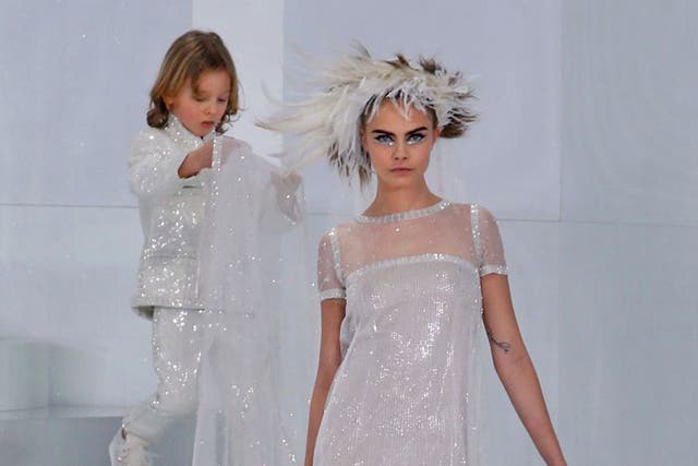 Cara Delevingne presents a creation from the Spring/Summer 2014 Haute Couture collection by German designer Karl Lagerfeld for Chanel fashion house during the Paris Fashion Week