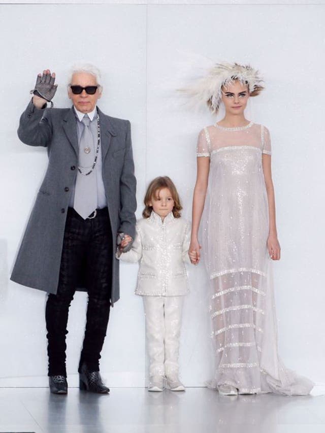 German fashion designer Karl Lagerfeld (L) acknowledges the public along with his godson Hudson and British model Cara Delevingne 