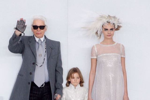 German fashion designer Karl Lagerfeld (L) acknowledges the public along with his godson Hudson and British model Cara Delevingne 