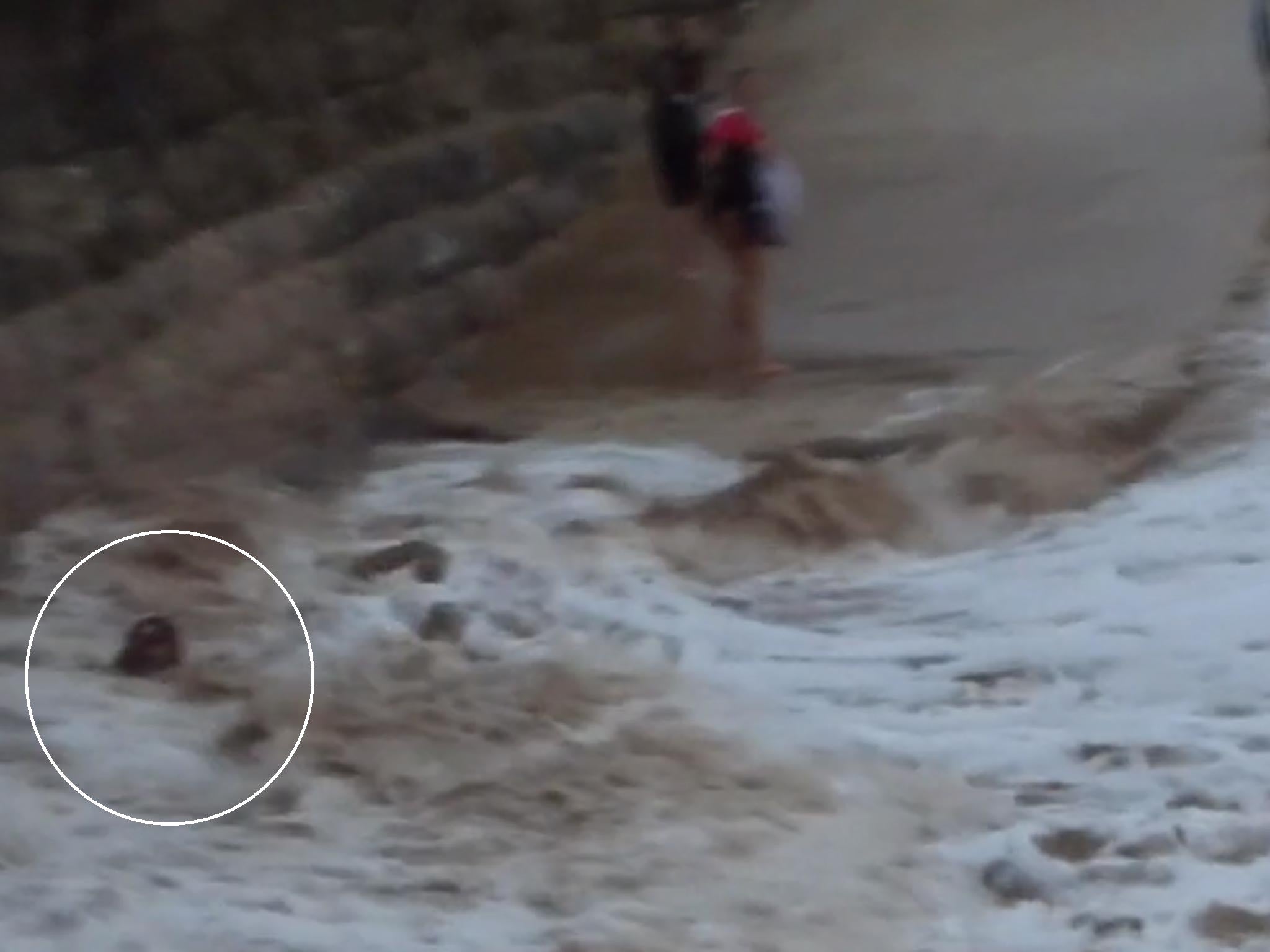 One moment the woman is dancing on the beach and the next she is swept away by a giant wave