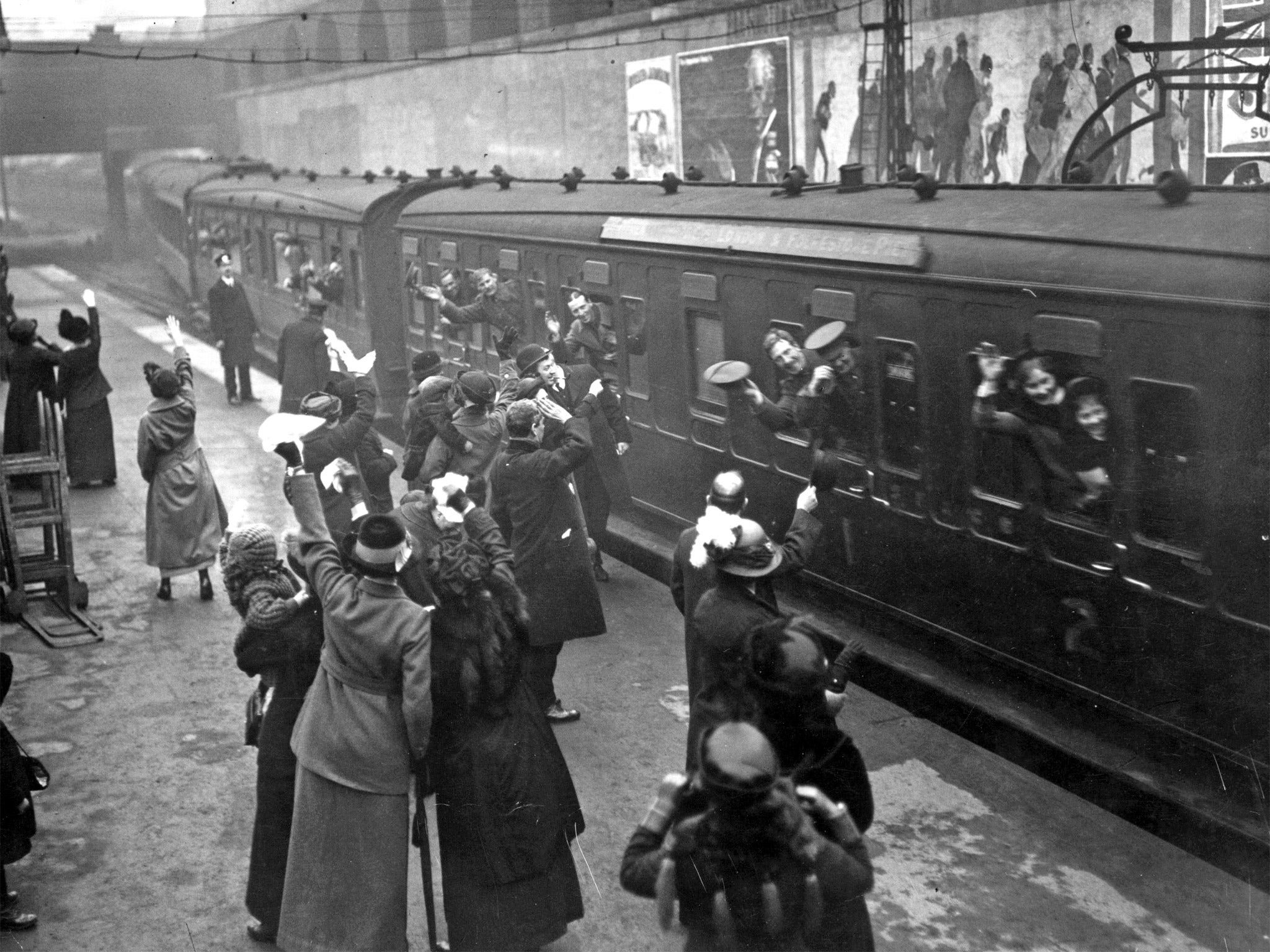 Soldiers waving good bye to loved ones as they leave Victoria Station in 1915