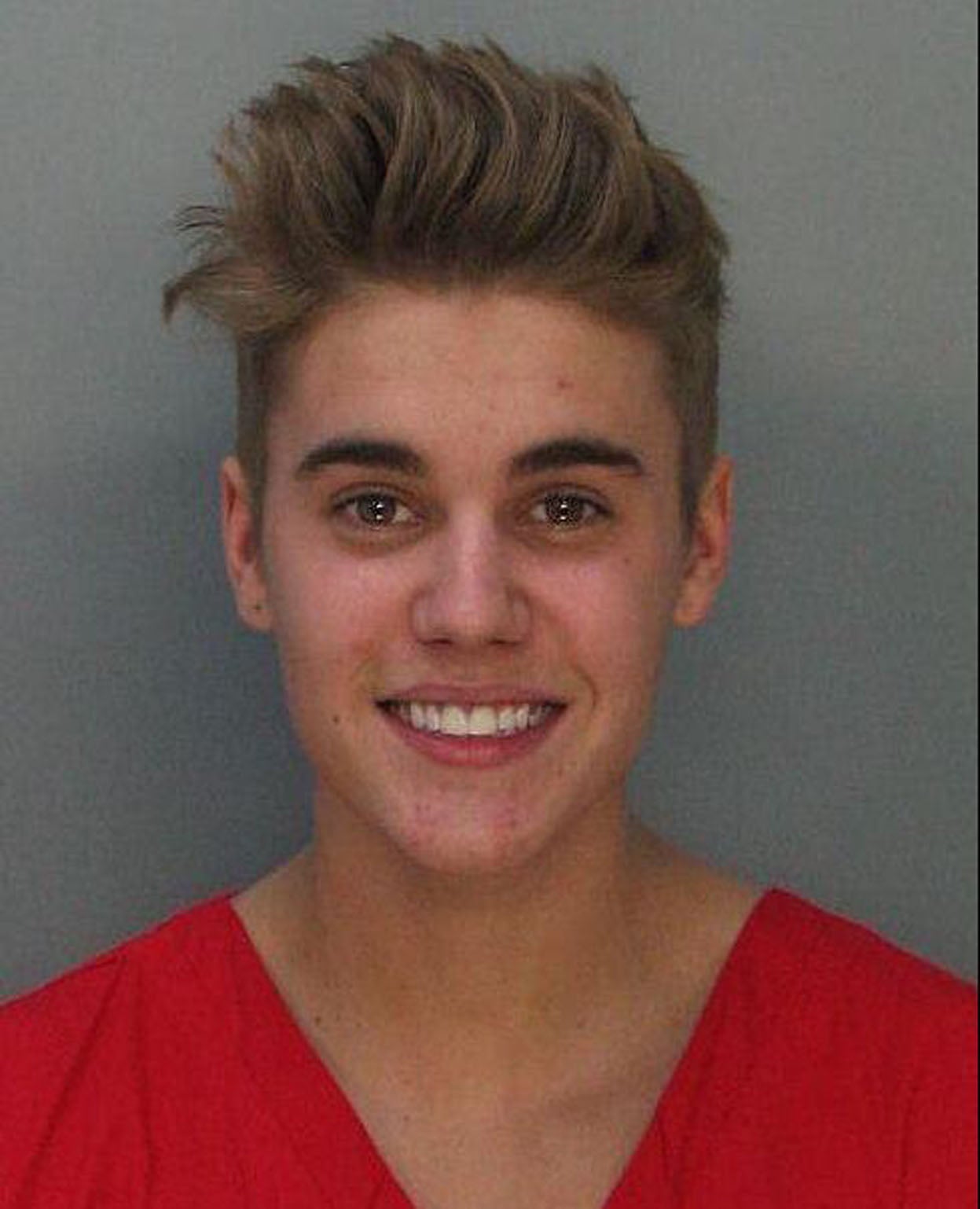 Dressed in orange, the singer appeared dishevelled, but in high spirits, as he smiled for police behind the camera