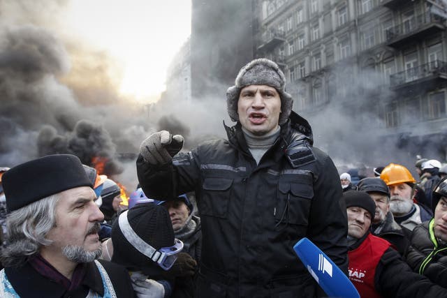 Opposition leader Vitaly Klitschko talks with pro-European integration protesters at the site of clashes with riot police in Kiev