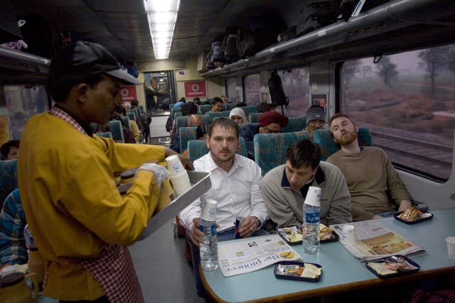 A waiter serves breakfast to passengers onboard the early morning Shatabdi Express train from New Delhi to Agra