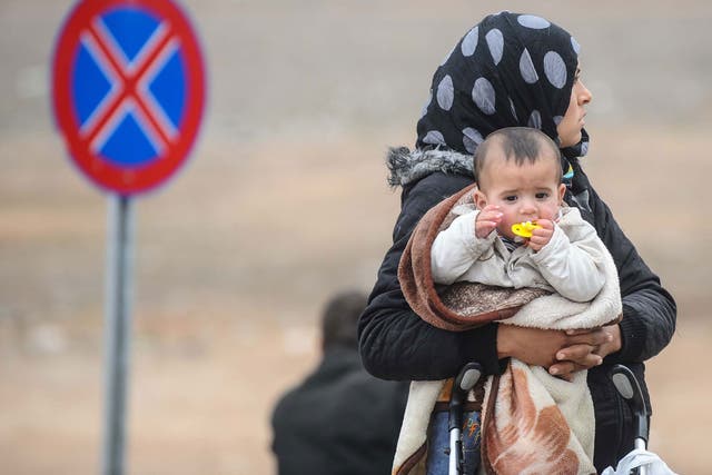 A Syrian woman with her baby at Syria's border with Turkey 