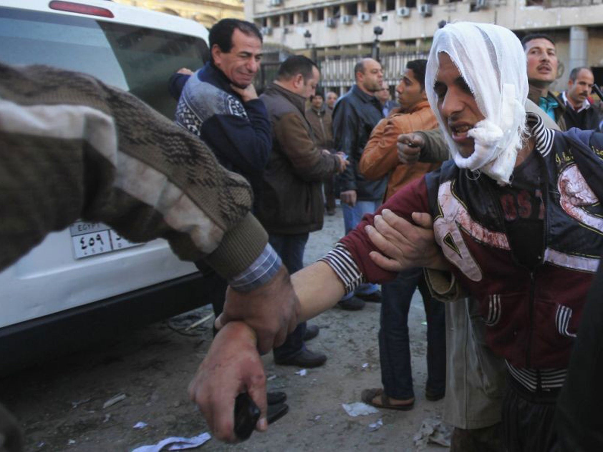 An injured police officer is led from the damaged Cairo Security Directorate (Reuters