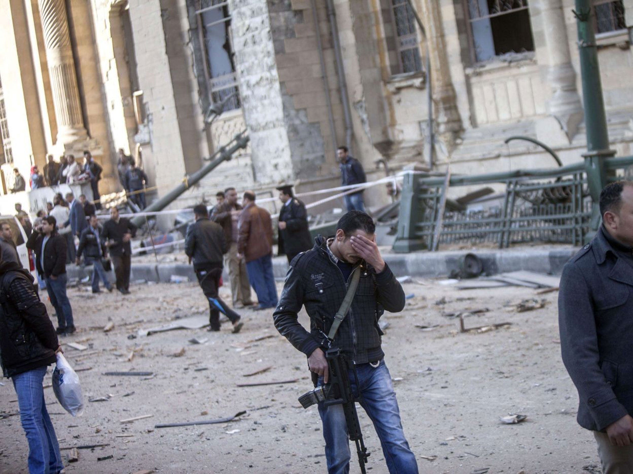 An Egyptian policeman reacts as he walks through the aftermath of the explosion that struck the Cairo police headquarters this morning