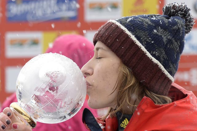 Lizzy Yarnold kisses her trophy after being crowned the women's skeleton world champion near Koenigssee, southern Germany