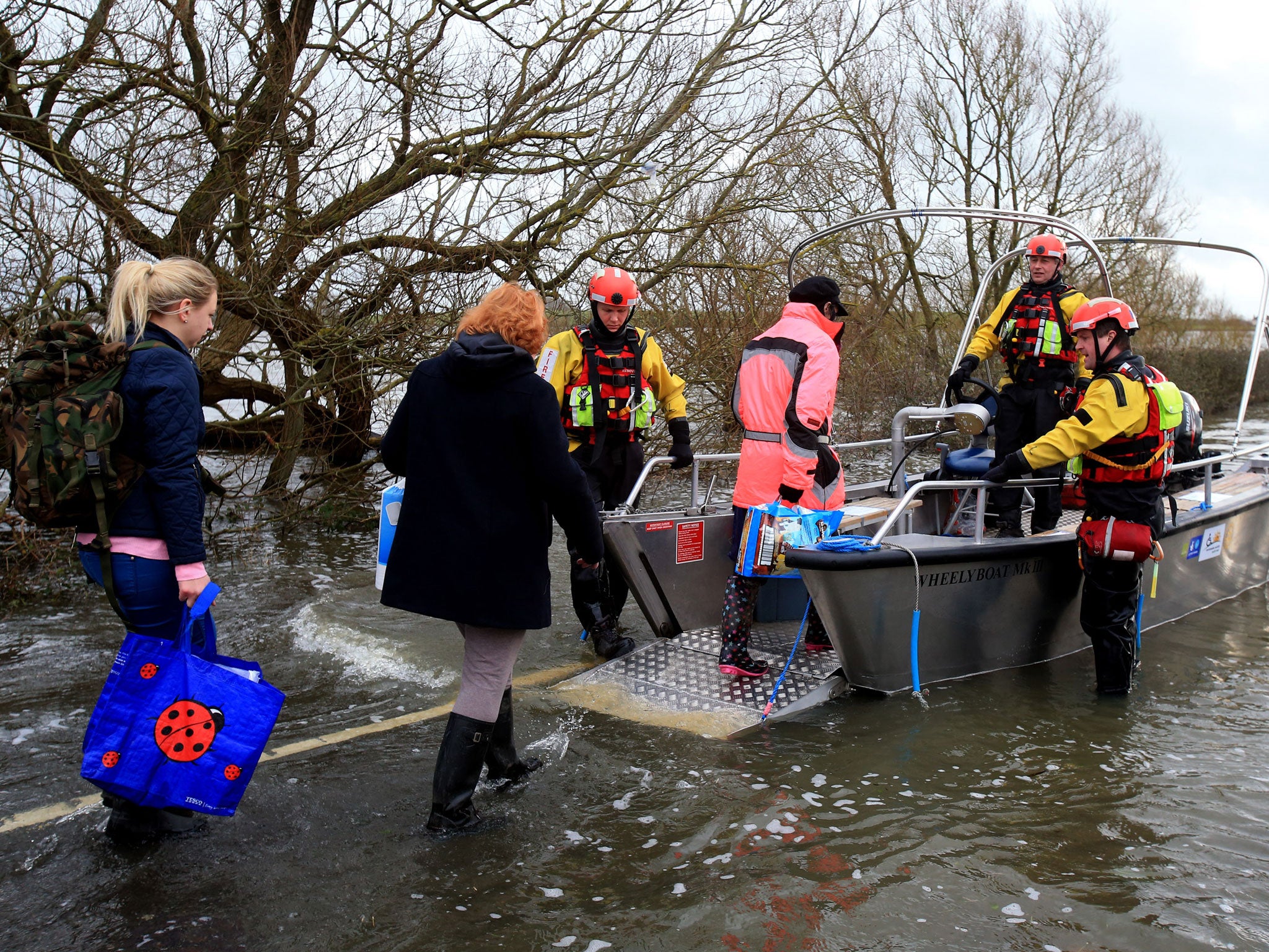 A fire crew helps villagers onto the boat in Muchelney (Getty Images)