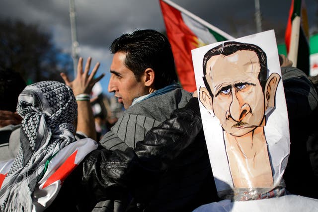Demonstrators protest against the Syrian President Bashar al-Assad outside the UN offices in Geneva during the talks on Friday