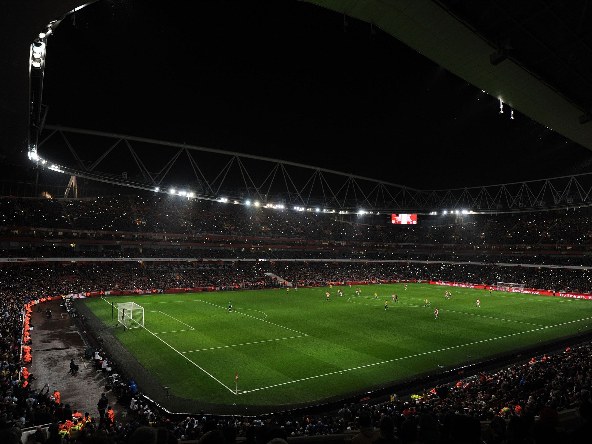 The fans hold up lights when the Emirates stadium floodlights switch to half power (Getty Images)