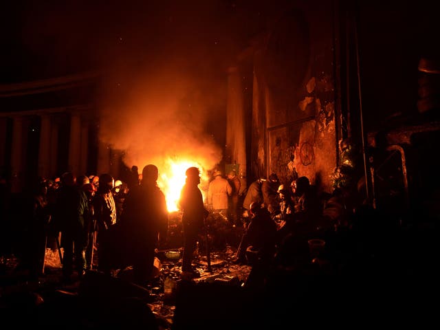 Anti-government protesters gather around a fire to get warm at a road block in Kiev on Sunday night
