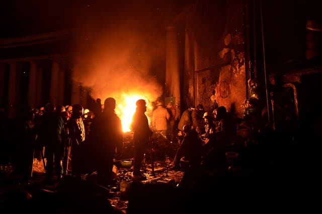 Anti-government protesters gather around a fire to get warm at a road block in Kiev on Sunday night