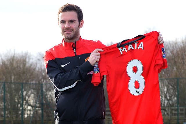 Juan Mata poses with his new Manchester United shirt on Monday