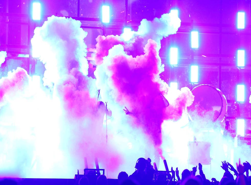 Kendrick Lamar and Imagine Dragons are shrouded by smoke at the 2014 Grammys