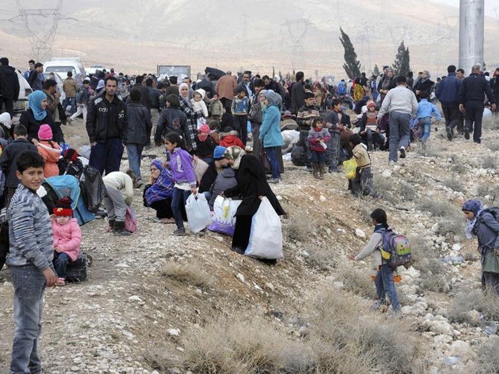Syrian residents are seen near a highway as they flee their homes in the Adra area