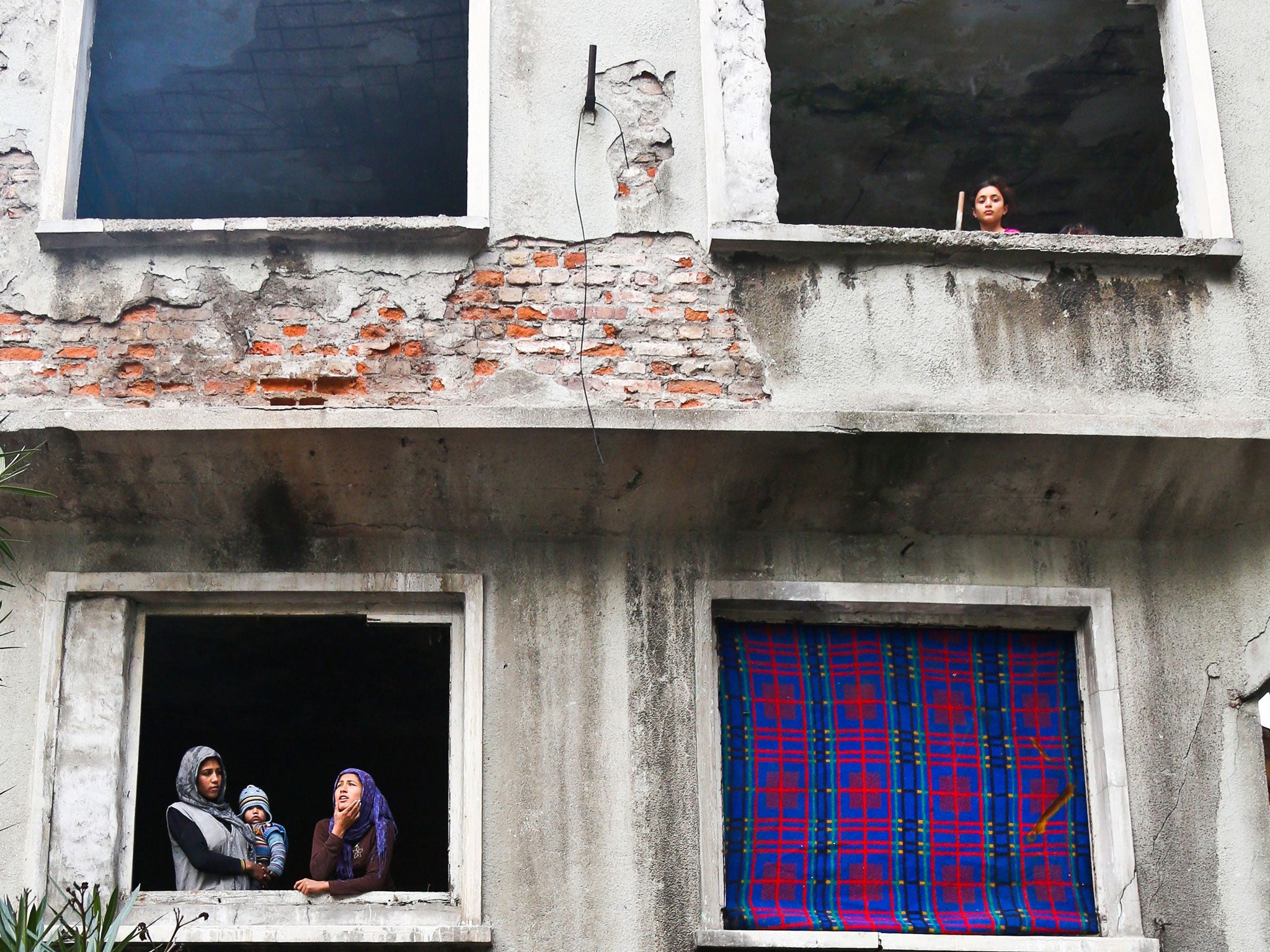 Syrian refugees look out from an evacuated house in Istanbul. Hundreds of Syrian refugees will be allowed to come to Britain under new government plans