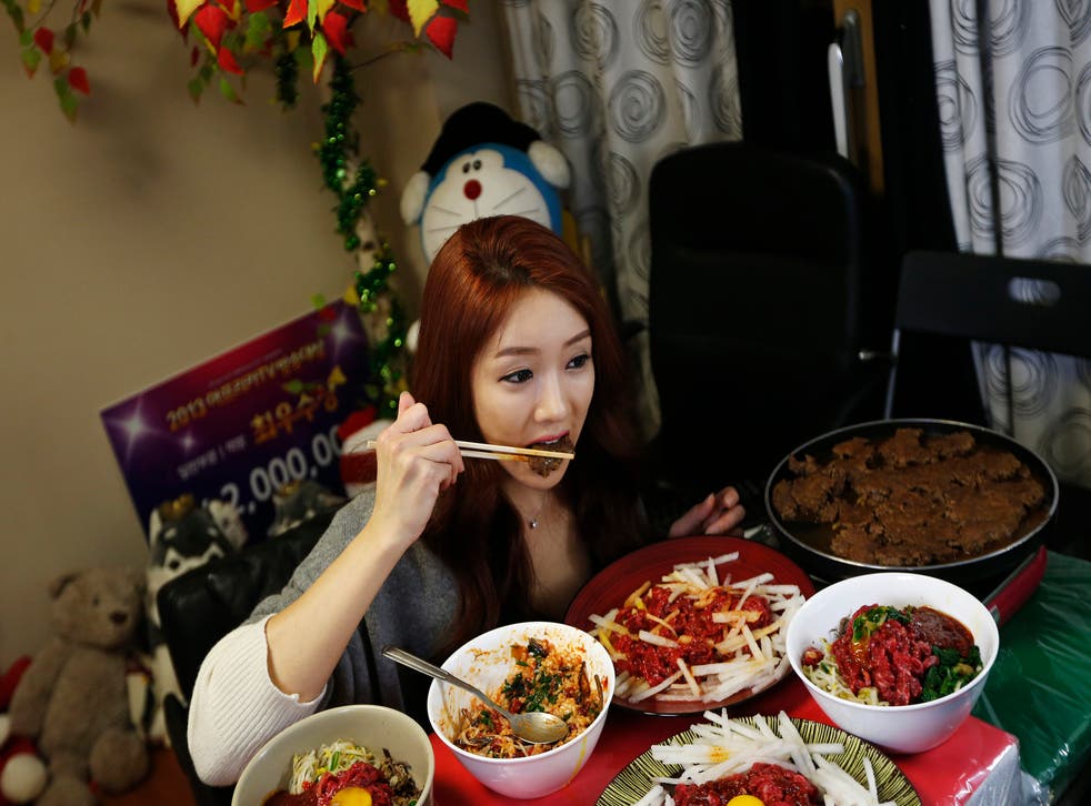 Park Seo-yeon, 34, eats in front of a video camera during her eating show in her apartment in Incheon, west of Seoul.