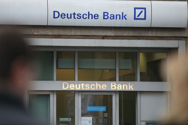 People walk past a branch of Deutsche Bank in Berlin, Germany