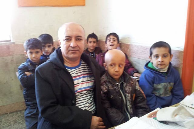 Iranian Teacher Ali Mohammadian with 8-year-old Mahan Rahimi, in a photo taken before Mahan's classmates followed their teacher and also shaved their hair. 