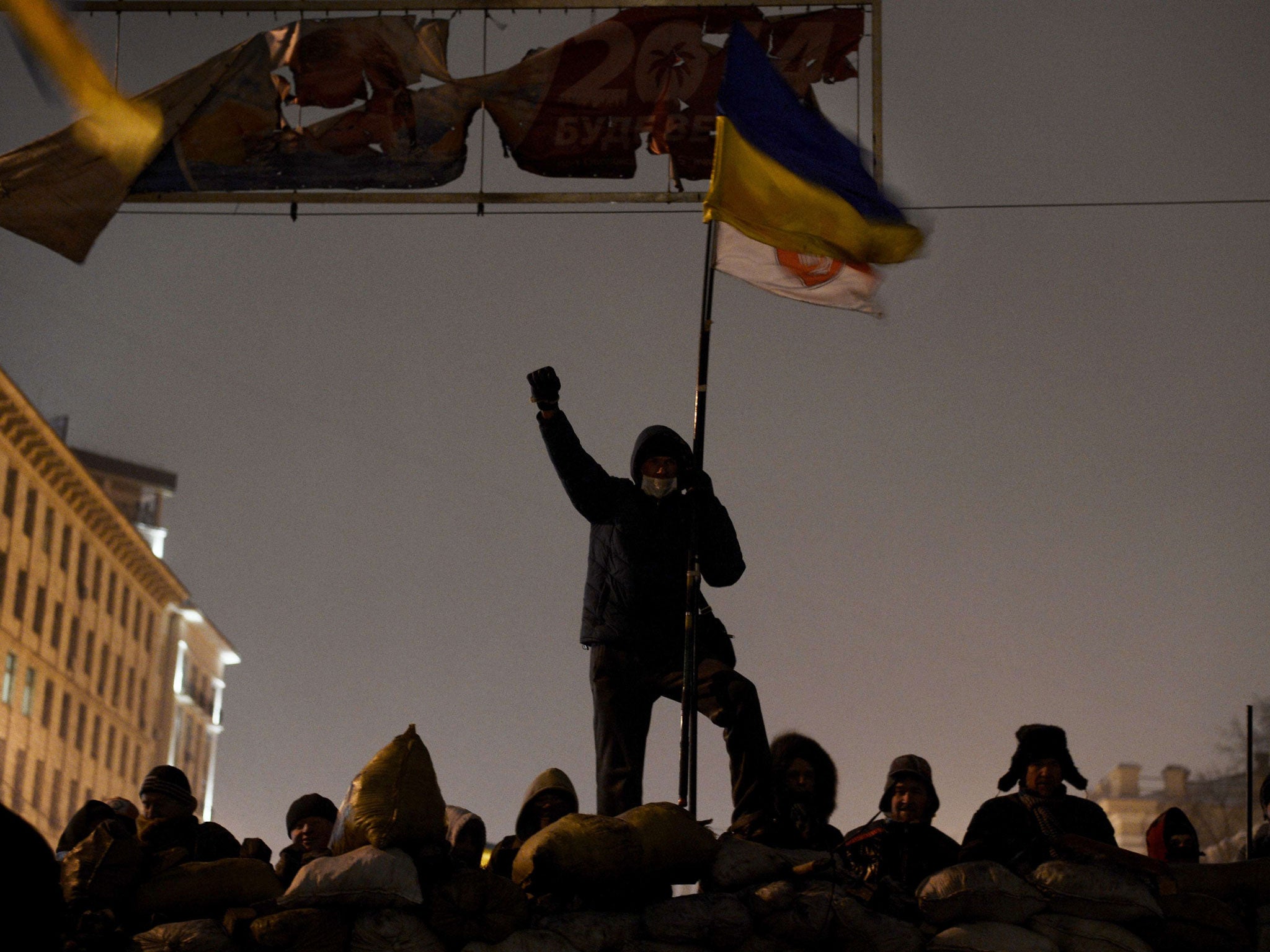 A demonstrator raises his fist as anti-government protesters gather at a road block in Kiev on January 28, 2014