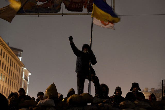 A demonstrator raises his fist as anti-government protesters gather at a road block in Kiev on January 28, 2014