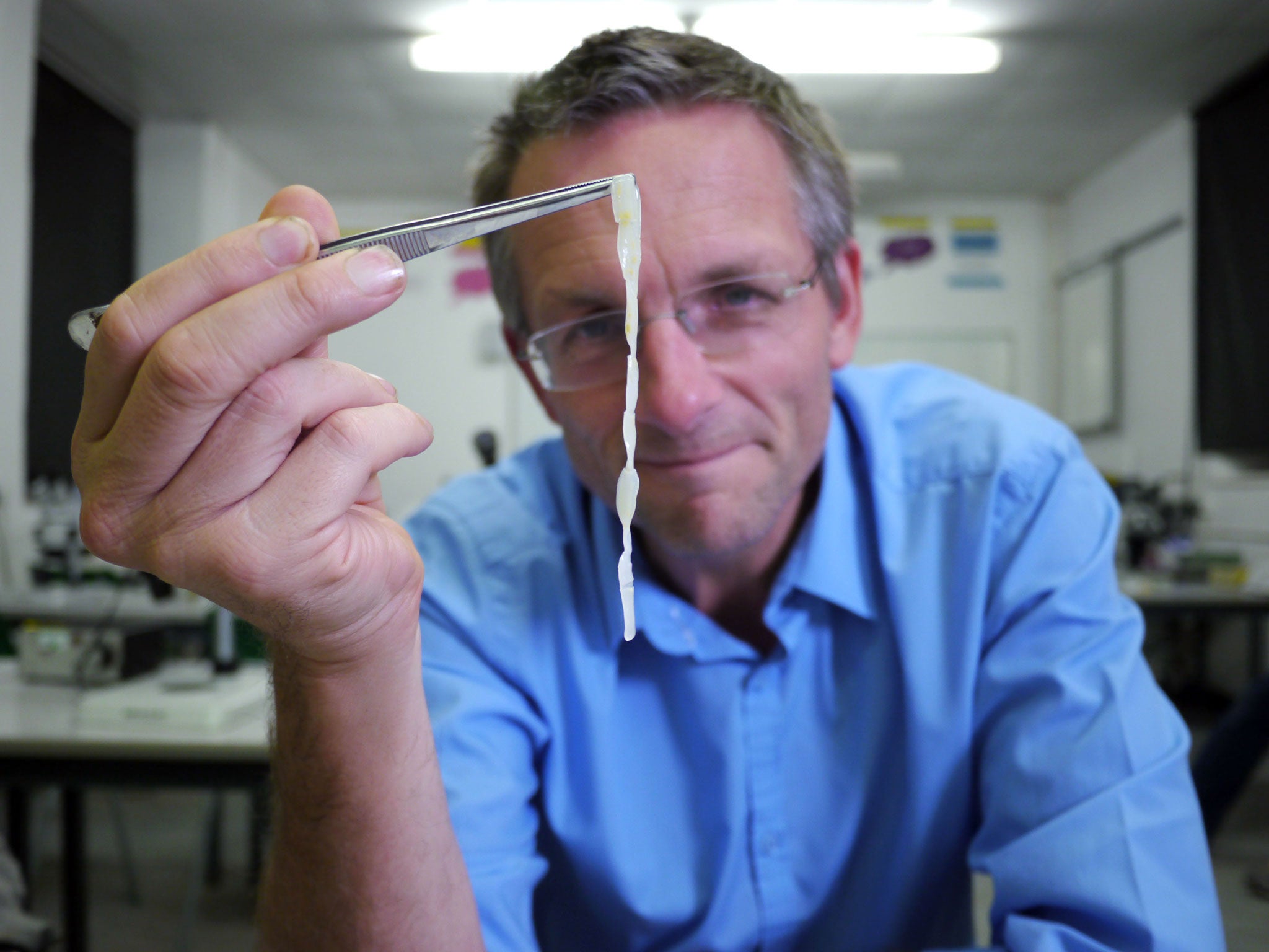 Michael Mosley holding up a piece of human tapeworm as Mosley lived with tapeworms in his guts for six weeks for a documentary