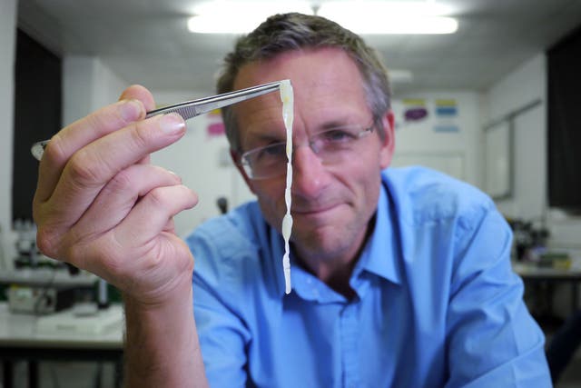 Michael Mosley holding up a piece of human tapeworm as Mosley lived with tapeworms in his guts for six weeks for a documentary 