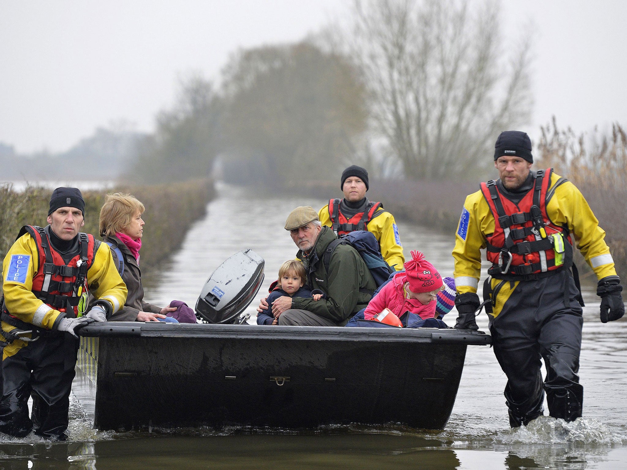 A boat operated by emergency services personnel carries local residents along a flooded road from the village of Muchelney on the Somerset Levels