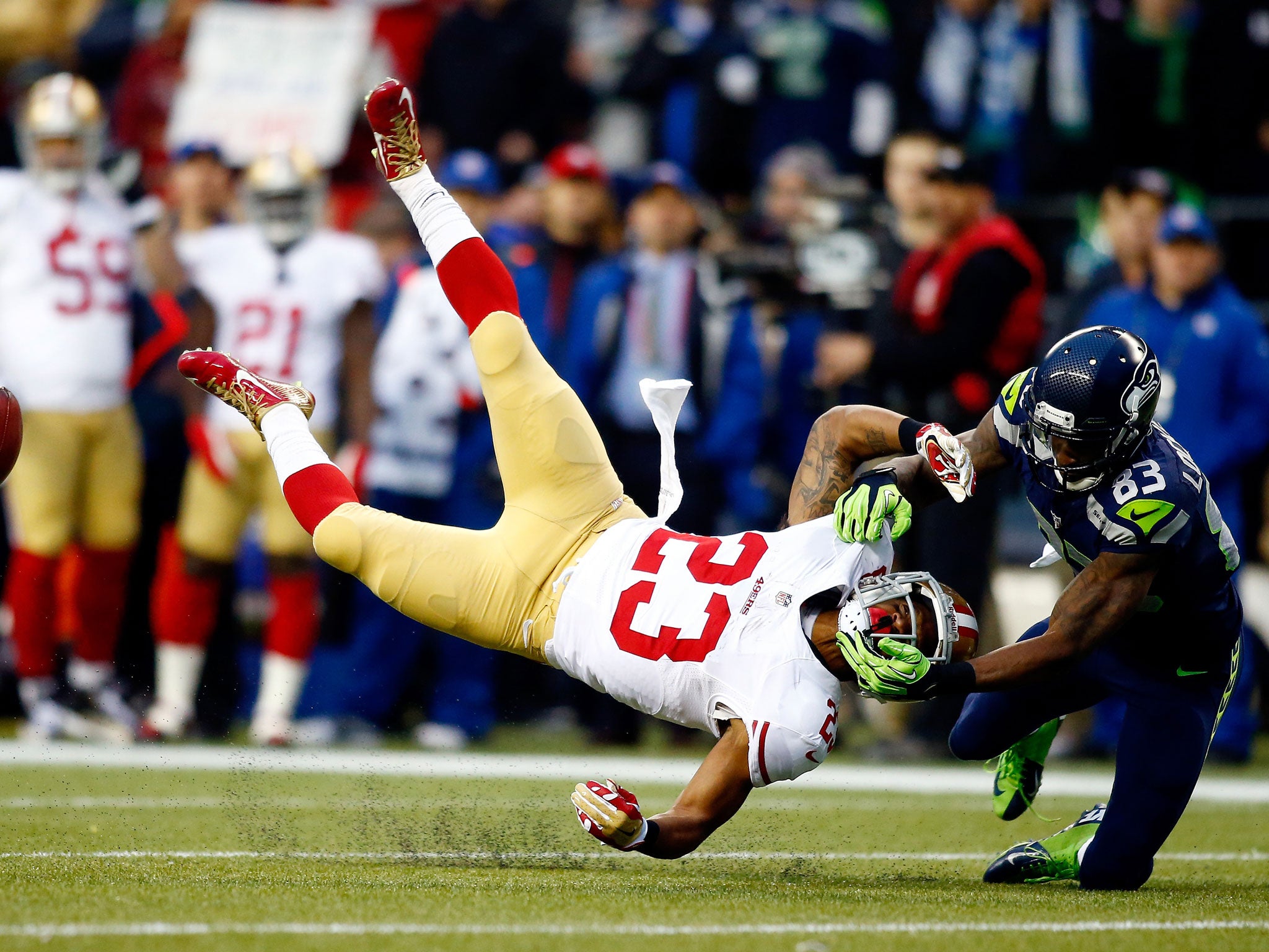 Kick returner LaMichael James of the San Francisco 49ers takes a hit to the head from the Seattle Seahawks' wide receiver Ricardo Lockette earlier this month