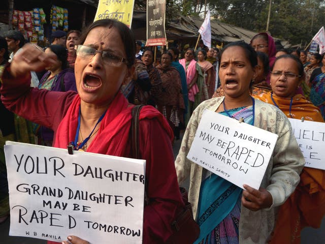 Activists carry posters as they shout slogans during a protest march against the gangrape and murder of a teenager, in India. The Indian politician has apologised after she said women invite rape. 