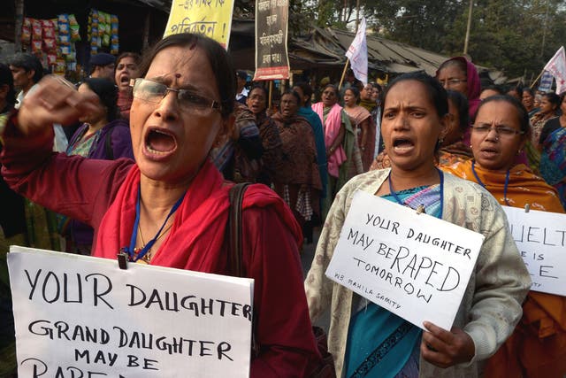 Activists carry posters as they shout slogans during a protest march against the gangrape and murder of a teenager, in India. The Indian politician has apologised after she said women invite rape. 