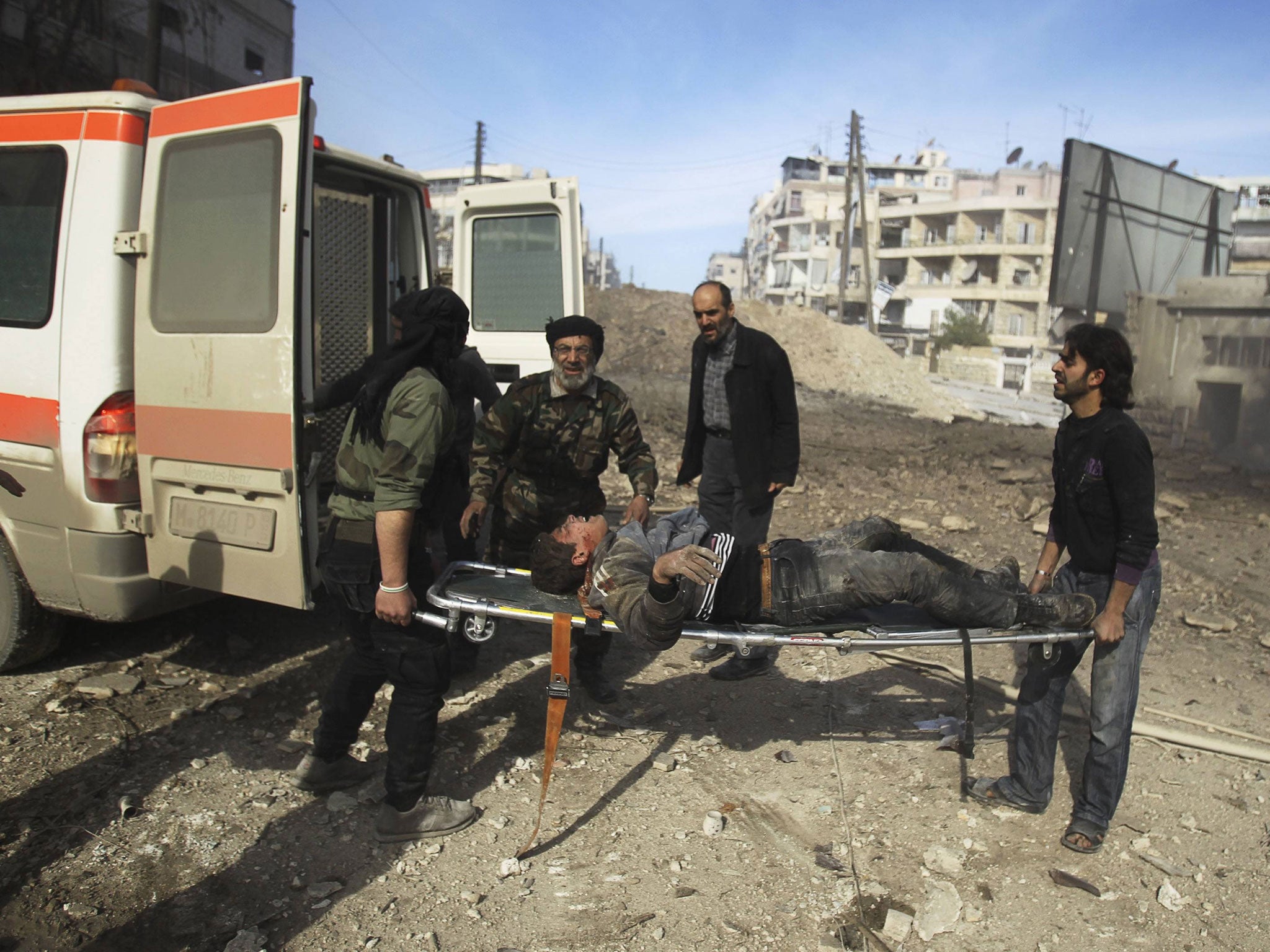 Men hold a wounded civilian on a stretcher at a site hit by what activists said were barrel bombs dropped by government forces in the Al-Ansari neighborhood of Aleppo