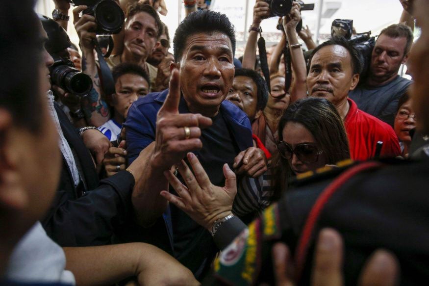Protesters demanding the right to vote argue with security and election officials at a district office where voting was called off in Bangkok