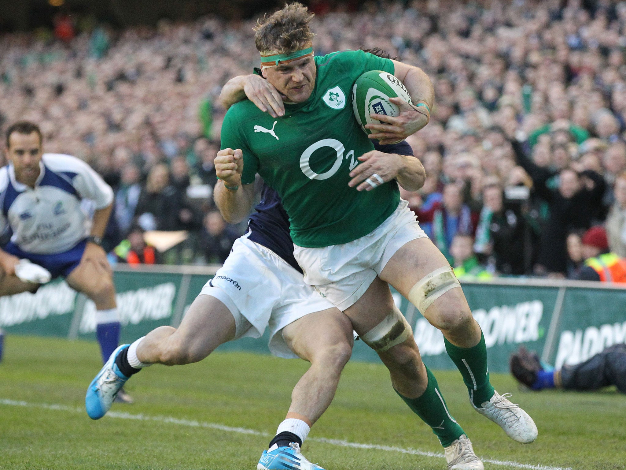 Ireland number 8 Jamie Heaslip breaks free from a tackle by Scotland's Max Evans