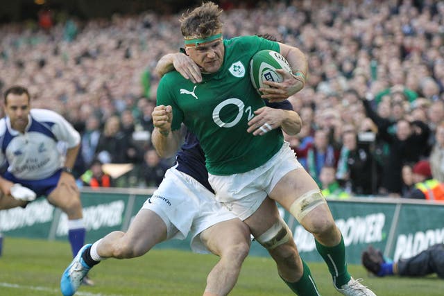 Ireland number 8 Jamie Heaslip  breaks free from a tackle by Scotland's Max Evans 