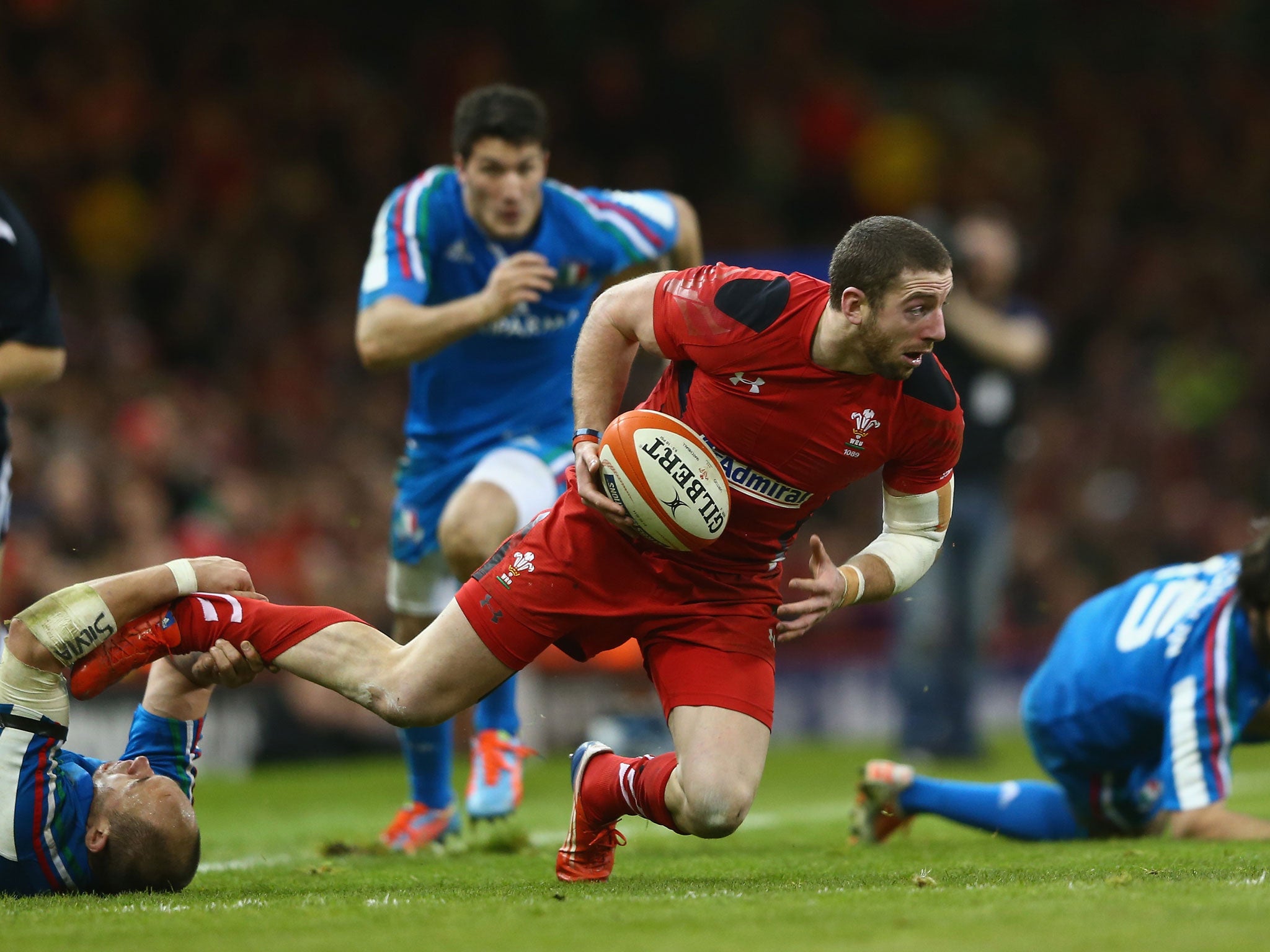 Alex Cuthbert of Wales is stopped by Italy’s Sergio Parisse in Cardiff