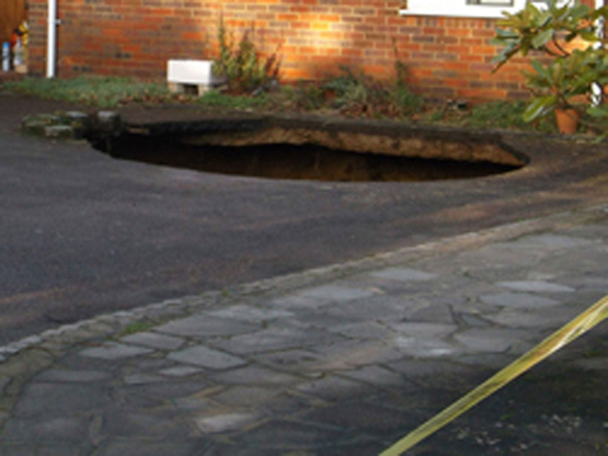 A 30ft deep sinkhole which has opened up in the driveway of a house in High Wycombe