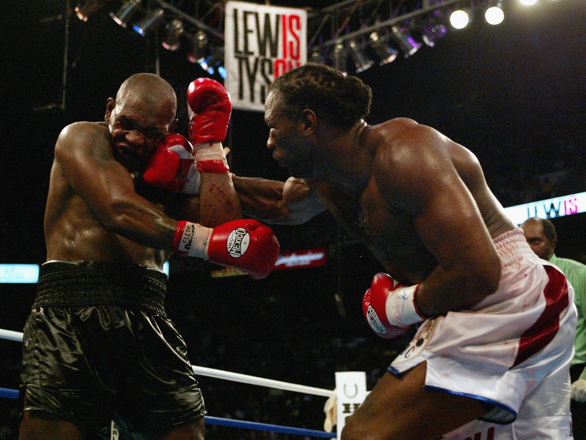 Lennox Lewis, right, lands another blow on Mike Tyson, left, during their 2002 fight in Memphis