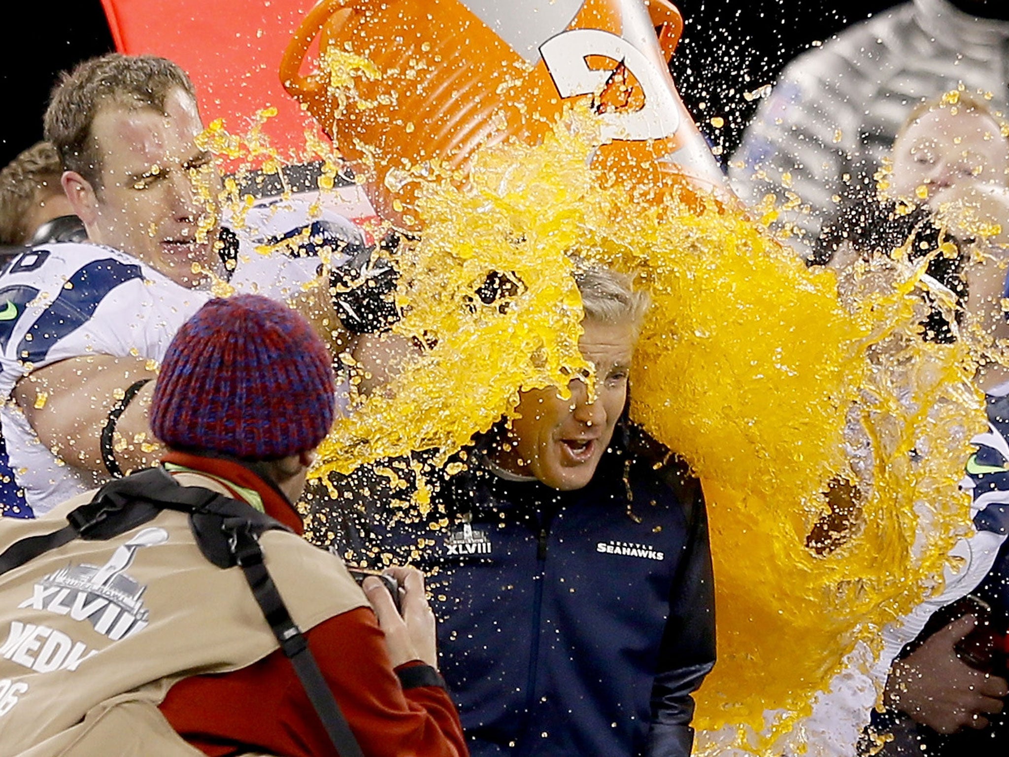 Tight end Zach Miller #86 and quarterback Russell Wilson #3 of the Seattle Seahawks dump Gatorade on head coach Pete Carroll