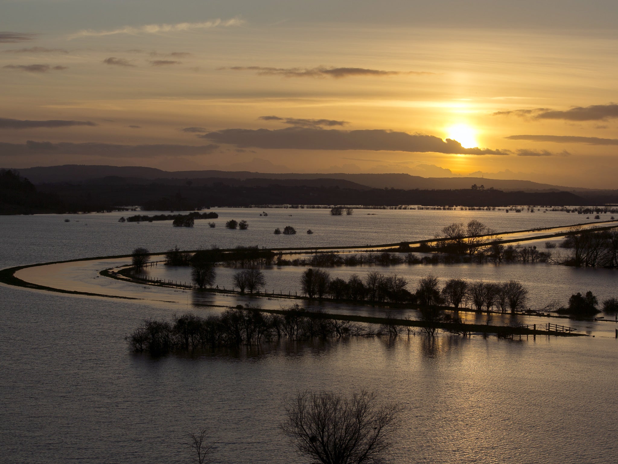The sun sets over flooded fields surrounding the River Tone that has burst its banks on the Somerset Levels viewed from Windmill Hill, in Stoke-St-Gregory on 2 Febuary 2014. Now thieves have been cashing in on the misery