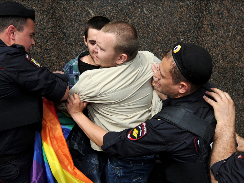 Russian riot policemen detain a gay and LGBT rights activist during an unauthorized gay rights activists rally in central Moscow on May 25, 2013.