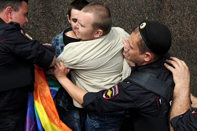 Russian riot policemen detain a gay and LGBT rights activist during an unauthorized gay rights activists rally in central Moscow on May 25, 2013. 
