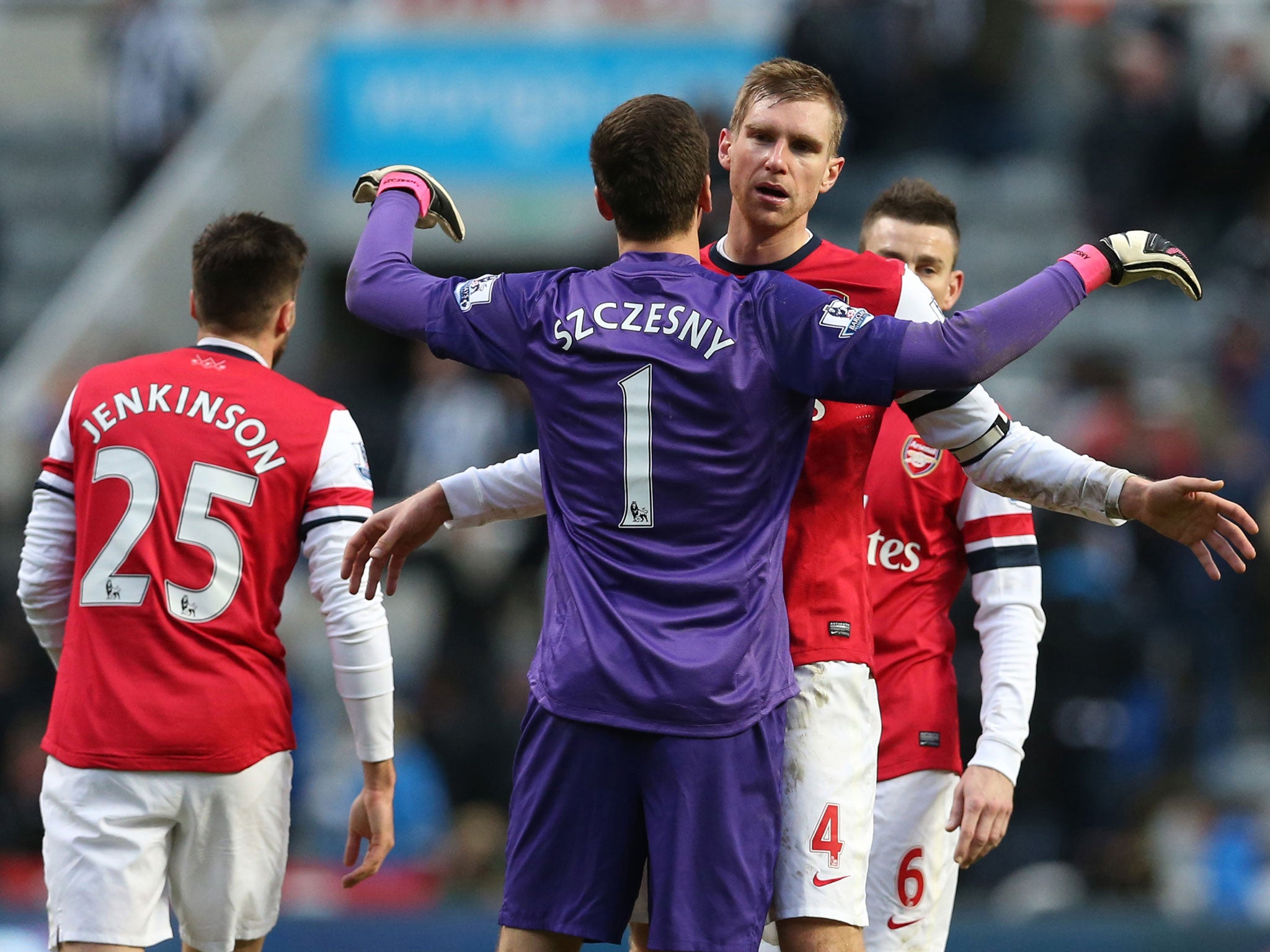 Arsenal's Polish goalkeeper Wojciech Szczesny (2nd L) embraces Arsenals German defender Per Mertesacker
